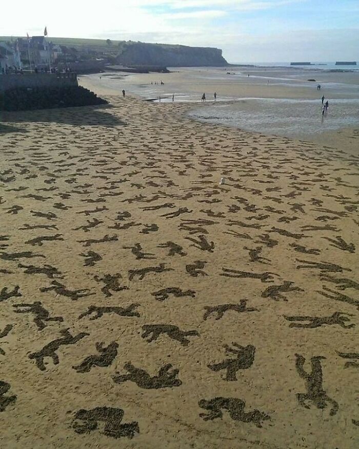 Figuras humanas de arena en la playa mostrando curiosidades en fotos históricas interesantes.
