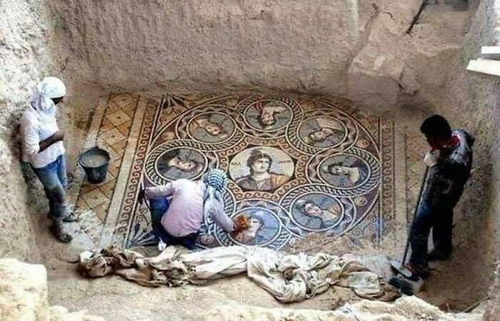 Personas excavando un mosaico antiguo con retratos, una interesante foto histórica que muestra curiosidades históricas.