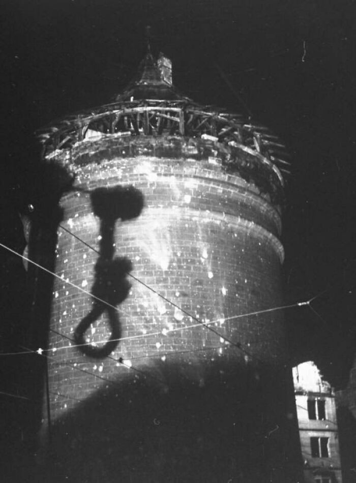 Sombra inquietante de una soga con noose proyectada sobre torre antigua en fotos del pasado impactantes.