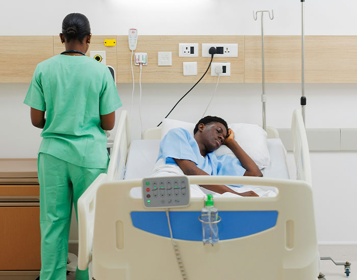 Paciente descansando en cama de hospital mientras enfermera revisa equipo médico, ilustrando casos y errores legales de clientes.
