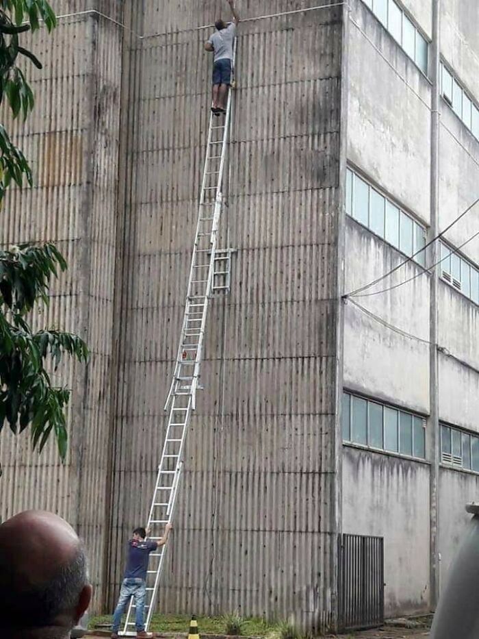 Hombre subiendo una escalera alta peligrosa junto a un edificio, ilustrando el riesgo que afecta la esperanza de vida masculina.
