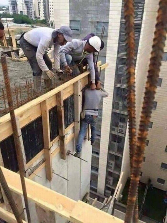 Trabajadores de construcción en riesgo extremo, ilustrando una de las razones por las que las mujeres viven más que los hombres.