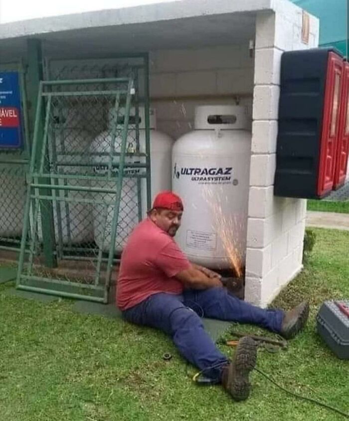 Hombre realizando soldadura peligrosa cerca de tanques de gas, riesgo ilustrativo en razones por las que mujeres viven más.