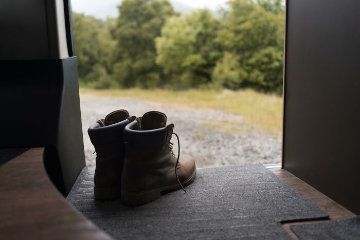 Botas marrones colocadas en la entrada de una casa, simbolizando consejos para mujeres que viven solas con seguridad y confort.
