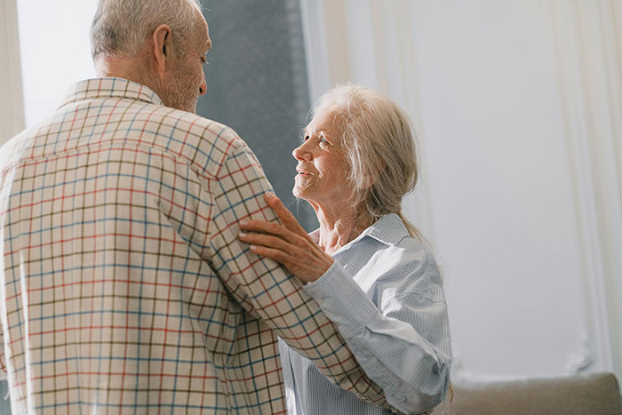 Pareja de personas mayores en gesto de cariño, reflejando momentos que cambiaron para siempre a trabajadores sanitarios.