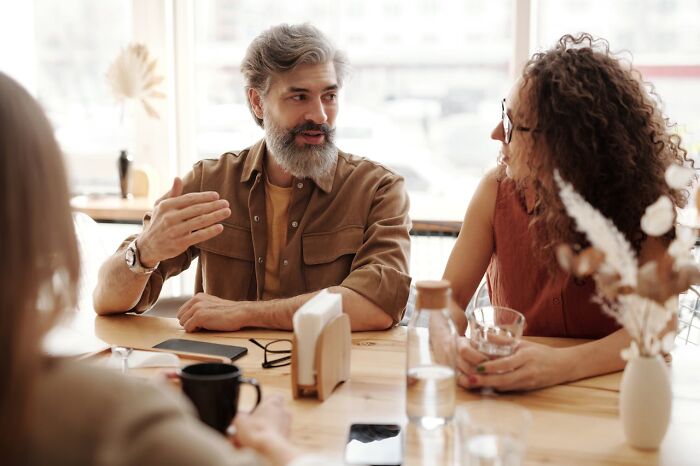 Hombres y mujeres discutiendo en una mesa, ilustrando momentos en que se corrigió a la persona equivocada y fallaron.