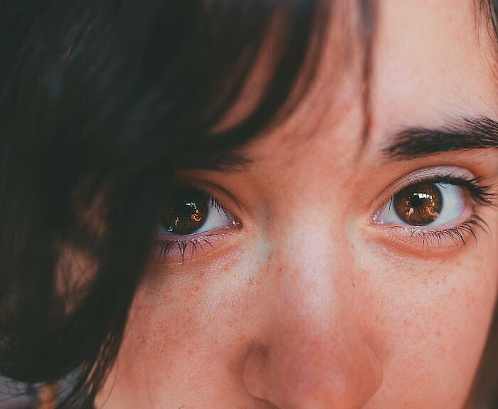 Primer plano de ojos y piel con pecas, mostrando características genéticas únicas de personas con genes buenos o malos.