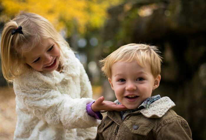 Niños pequeños en ropa de otoño compartiendo momentos naturales con ambientes de conversaciones privadas terroríficas.
