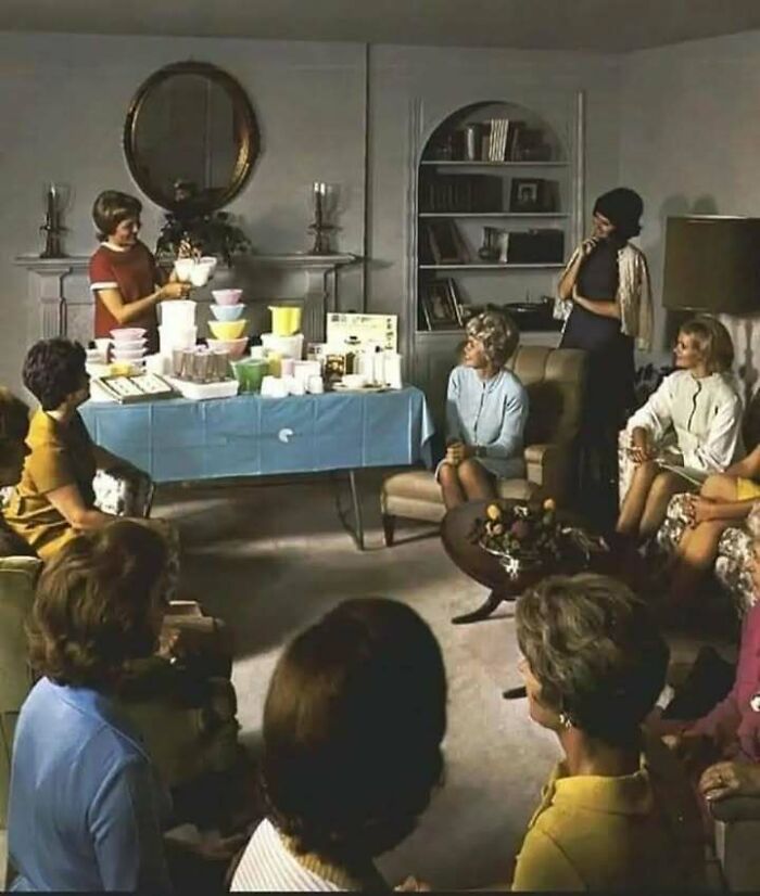Grupo de mujeres en reunión social con artículos para el hogar, mostrando un lado distinto de la historia.
