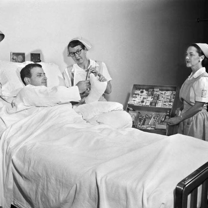 Paciente hospitalizado con férula en el pie, acompañado por dos enfermeras, mostrando un lado distinto de la historia.