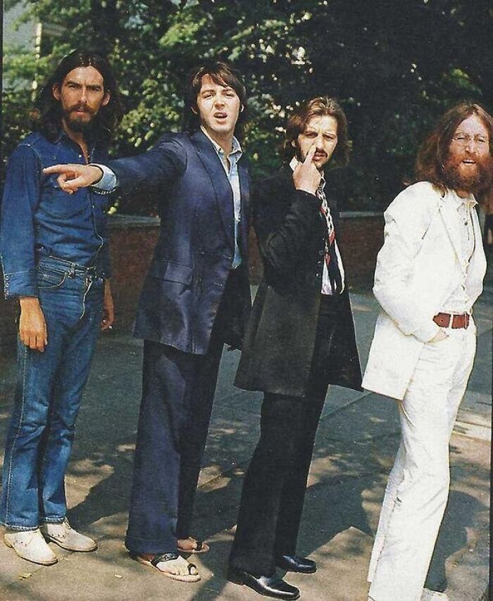 Grupo de cuatro hombres en ropa de los años 70, foto con ángulo alternativo mostrando estilo y actitudes únicas.