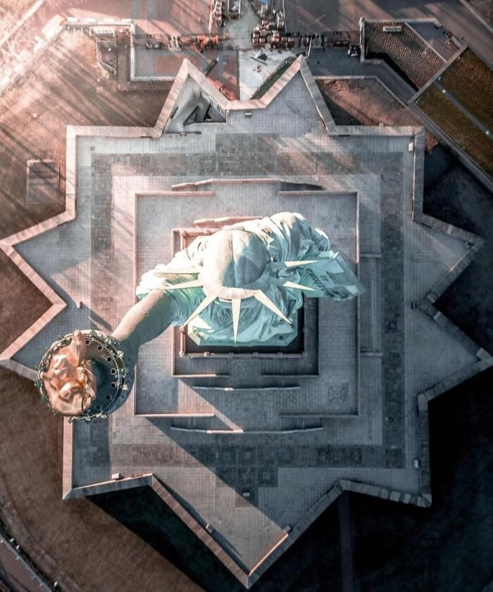Foto aérea de la Estatua de la Libertad mostrando ángulos alternativos poco comunes y detalles arquitectónicos únicos.