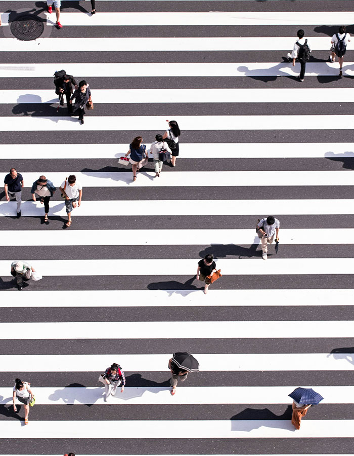 Personas caminando en pasarela peatonal grande en Japón, mostrando la tendencia de caminar 30 minutos para mejor salud.