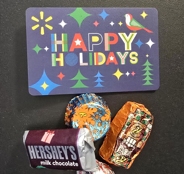 Tarjeta con mensaje festivo y chocolates sobre fondo negro en un entorno que refleja lugares de trabajo tóxicos.
