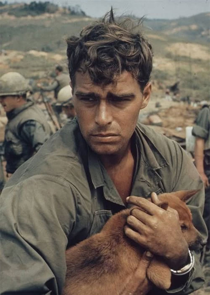 Soldado abrazando un perro durante un momento de descanso en fotos históricas del pasado inédito.