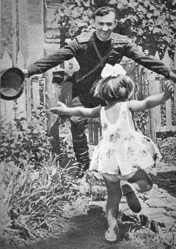 Soldado saludando con alegría a niña pequeña en una curiosa foto histórica capturada en el pasado inédito.