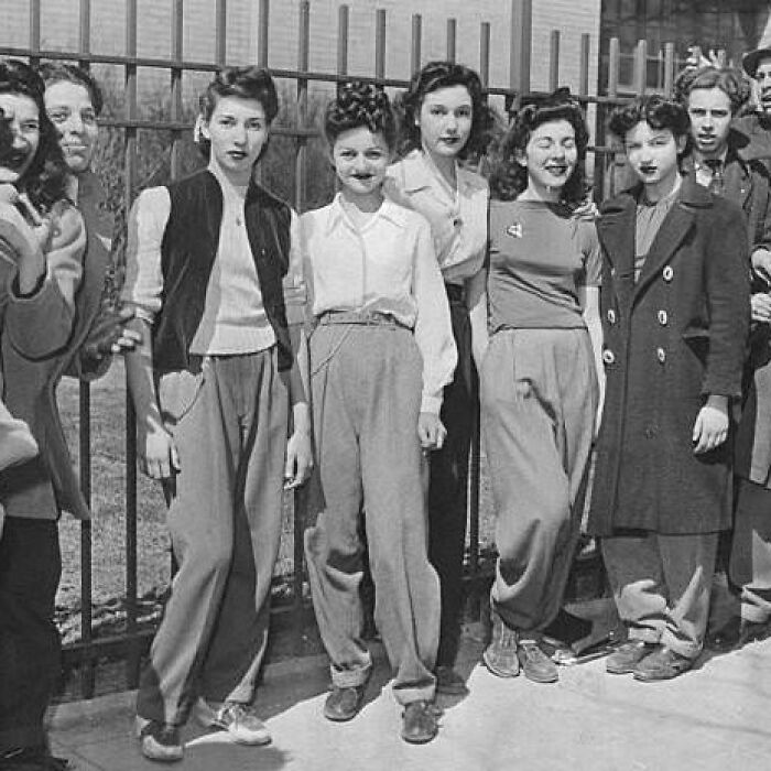 Mujeres posando frente a una reja en una foto histórica en blanco y negro mostrando curiosidades del pasado.