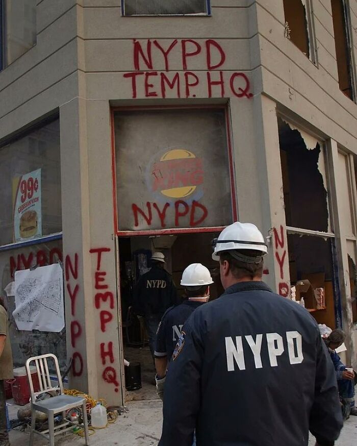 Policías del NYPD en sede temporal con grafitis en edificio dañado, foto histórica que muestra curiosidades de la historia urbana.