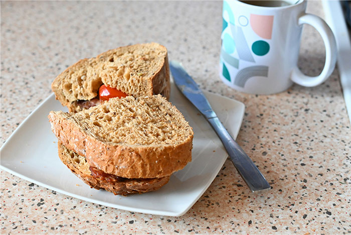 Sándwich sencillo en plato blanco junto a taza, simbolizando momentos de pérdida de atracción en pareja relatados por mujeres.