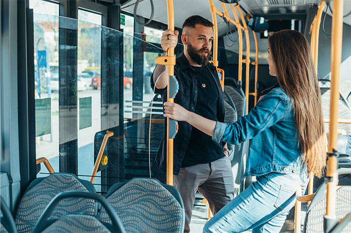 Hombre y mujer en transporte público, momento de pérdida de atracción en pareja con expresión seria y distante.