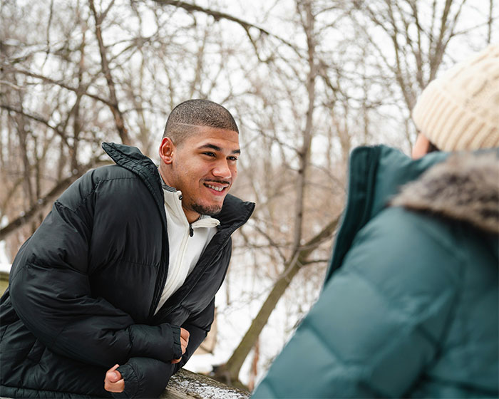 Pareja conversando al aire libre en invierno, mostrando momento de atracción perdida entre mujeres y sus parejas.