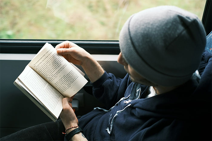 Hombre leyendo un libro en el transporte, relacionado con el momento en que mujeres perdieron atracción por su pareja.