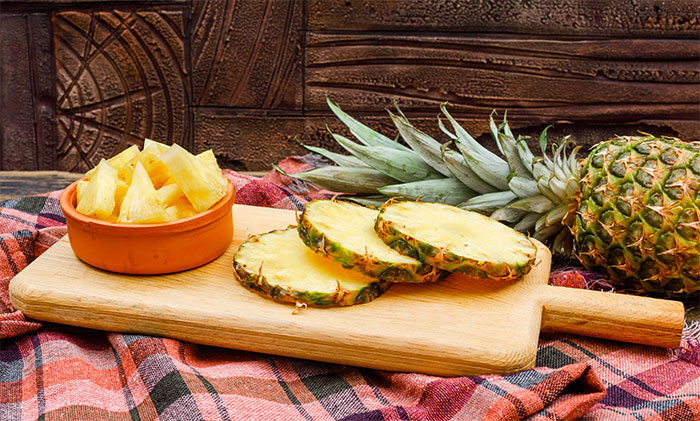 Rodajas y trozos de piña fresca sobre tabla de madera, en el contexto de experiencias de camareros en citas terribles.