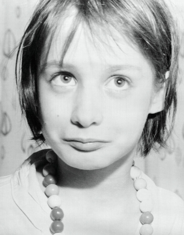 Niña con expresión inquietante y mirada perdida en una foto en blanco y negro que parece normal pero tiene historia oculta.