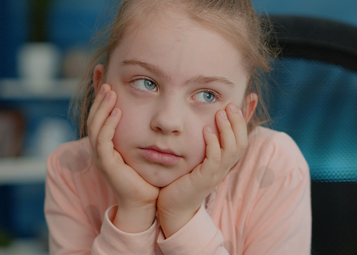 Niña con gesto pensativo y preocupado, reflejando desagradables presentimientos que podrían hacerse realidad.