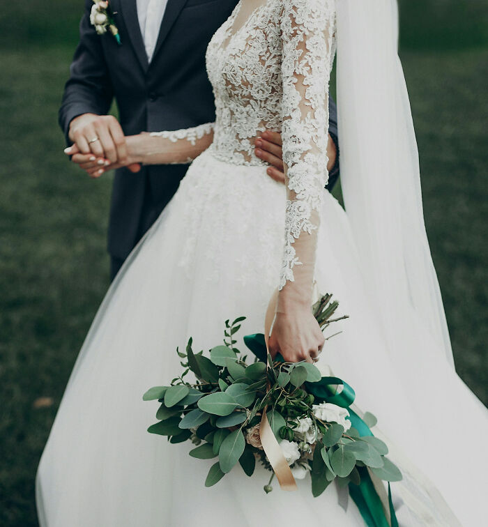Pareja de recién casados, novia con ramo y vestido de encaje, destacando temas desquiciados y deprimentes sobre familias.