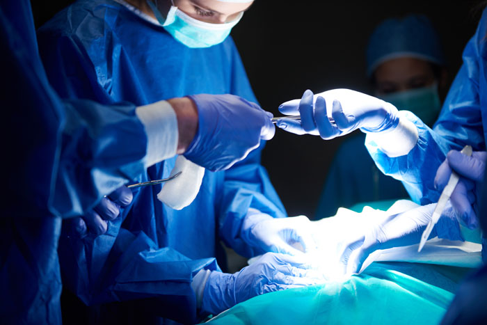 Equipo de cirujanos en hospital realizando procedimiento, ilustrando errores terribles en centros médicos.
