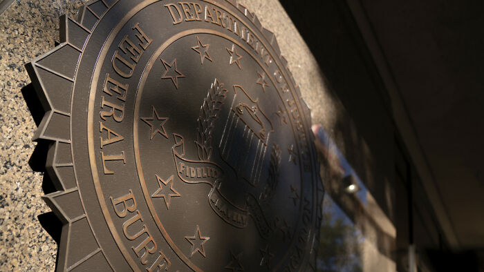 Placa del FBI en edificio oficial, simbolizando casos de personas despedidas por actos inapropiados en el trabajo.