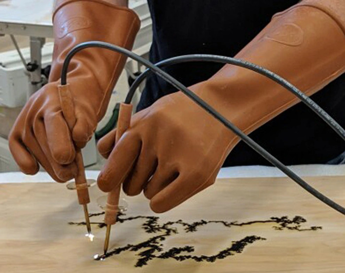 Persona con guantes protectores realizando grabado con soldador, imagen relacionada con retos fatales de TikTok peligrosos.