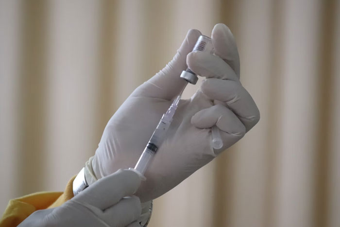 Manos con guantes preparando una jeringa en hospital, relacionado con errores terribles en hospitales.