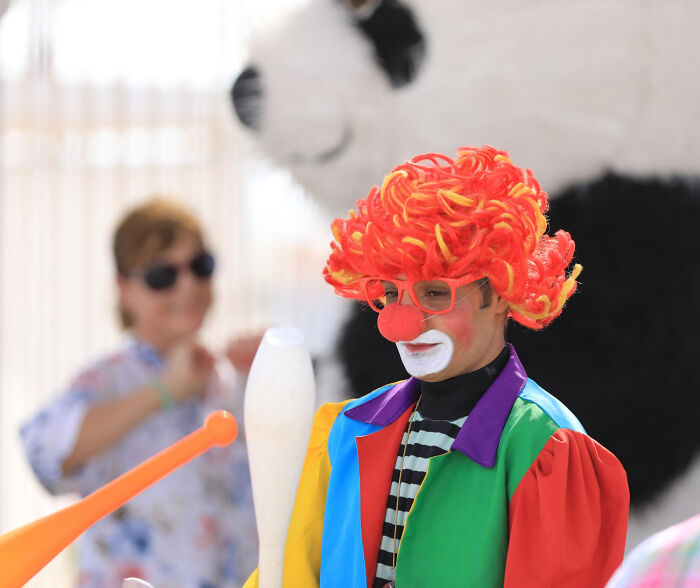 Payaso con peluca roja y nariz roja en evento al aire libre, relacionado con casos que detectives privados no olvidan.