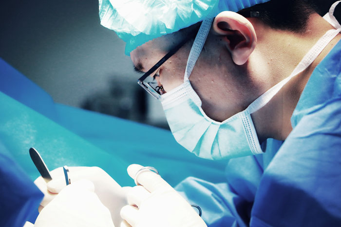 Médico en quirófano realizando procedimiento en hospital, representando errores terribles en hospitales reales.