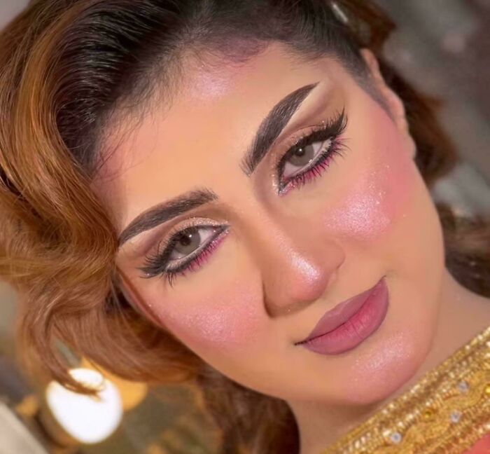 Mujer con maquillaje exagerado y peinado que evidencia arrepentimiento tras salir del salón de belleza desagradada.