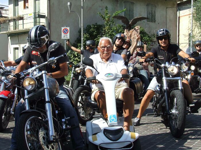 Hombre mayor en scooter eléctrico entre motoristas en motocicletas, mostrando actitud de personas a las que todo les da igual.