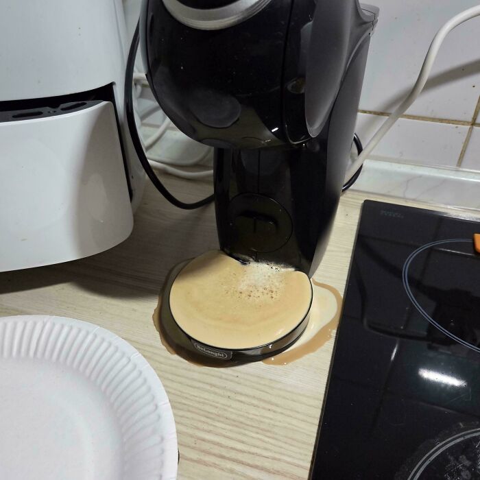 Cafetera con café derramado en la encimera mostrando consecuencias de olvidar algo importante en la cocina.