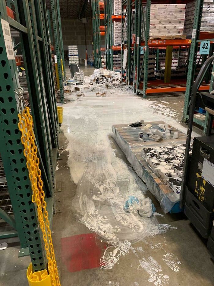 Desastre en almacén con líquido derramado y productos caídos, mostrando un día peor en el trabajo para muchas personas.
