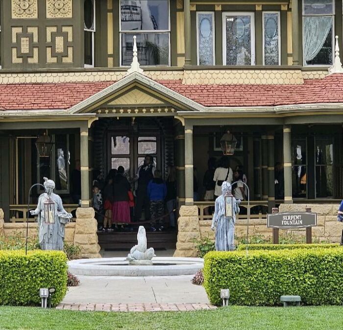 Casa histórica antigua con fuente y estatuas en jardín, relacionada con misterios interesantes que desconciertan a la gente.