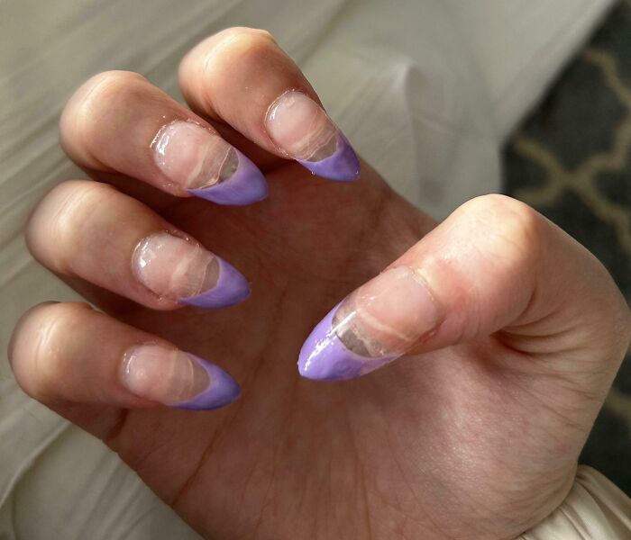 Uñas mal hechas con esmalte mal aplicado en salón de belleza causando arrepentimiento y disgustos visibles.
