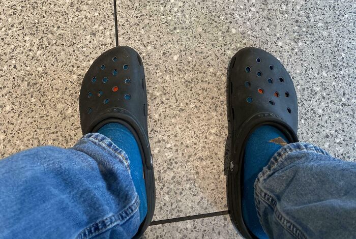 Zapatos negros usados con calcetas azules rotas, mostrando a una persona que olvidó algo importante y documentó las consecuencias.