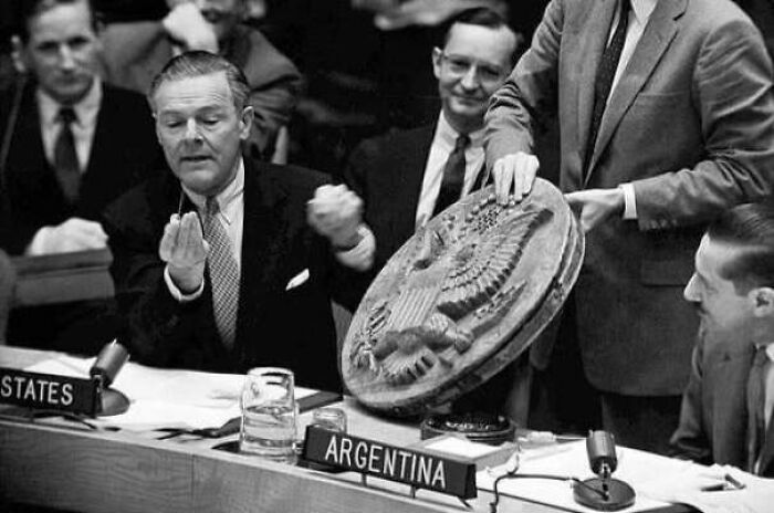 Hombres en una reunión diplomática mostrando un objeto grande con detalles de águila, en contexto de datos fascinantes históricos.