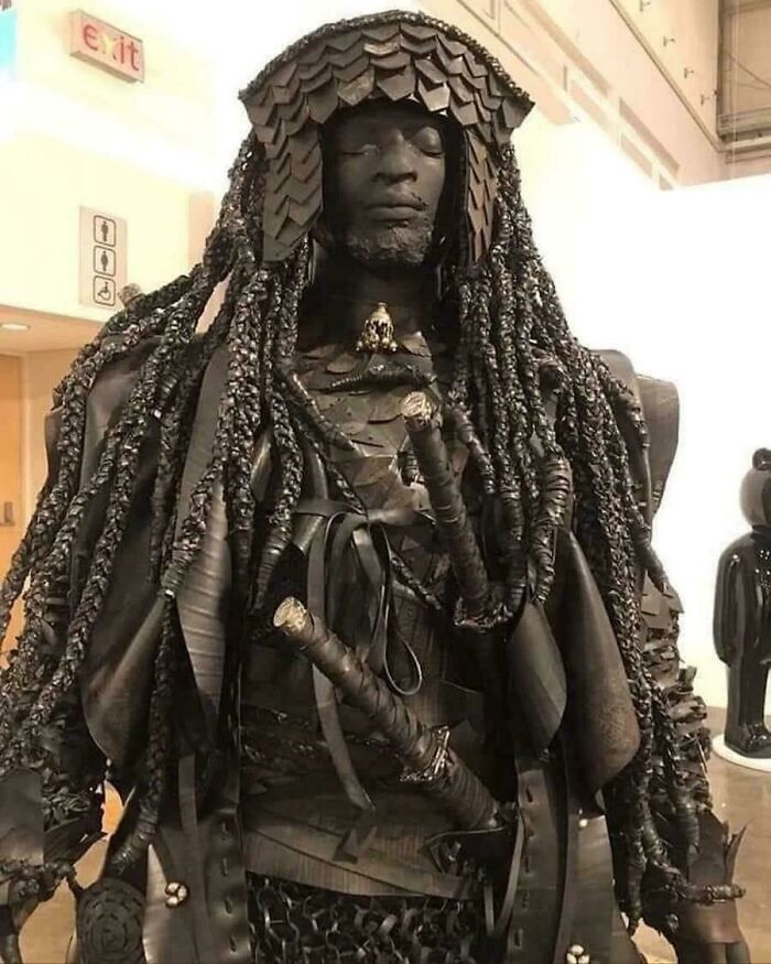 Escultura de guerrero con trenzas y armadura detallada, mostrando datos fascinantes de arte y cultura visual.