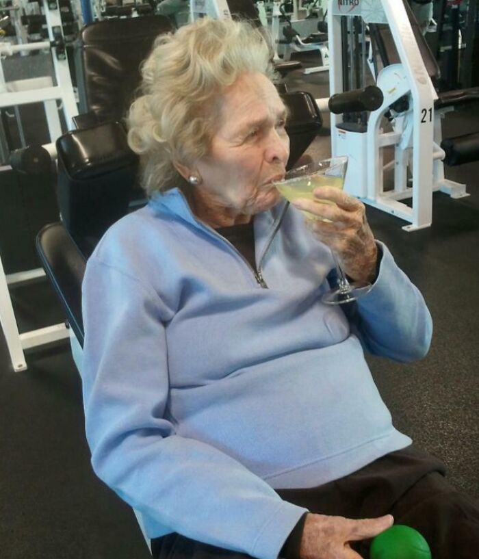 Anciana despreocupada en el gimnasio disfrutando una bebida, ejemplo de personas a las que todo les da igual.