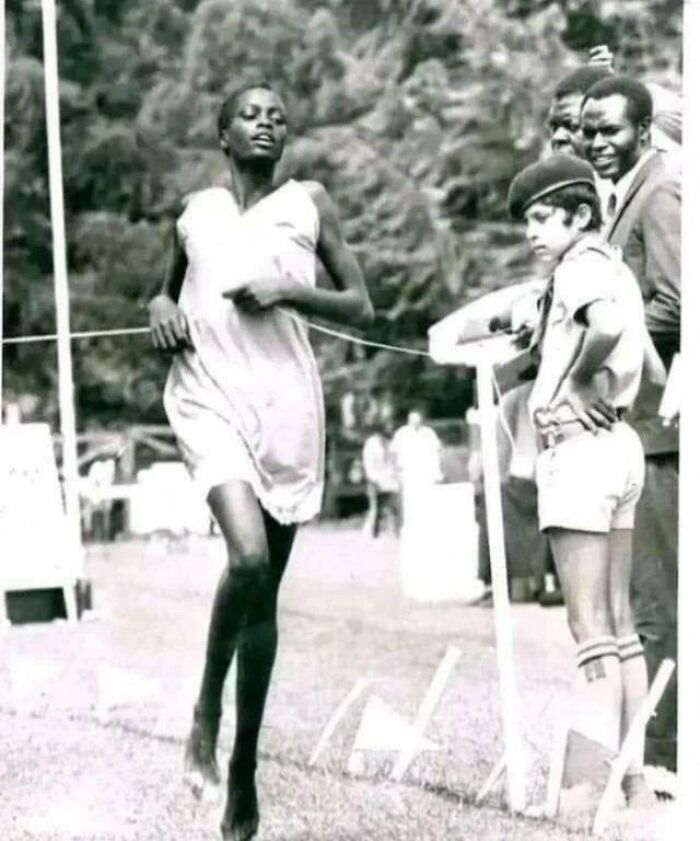 Corredora africana cruzando la meta en carrera, imagen histórica que representa datos fascinantes sobre el deporte y superación.
