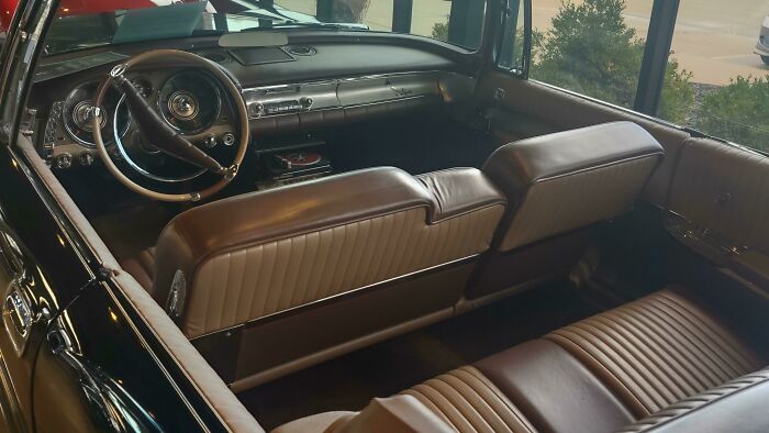 Interior de un coche clásico con asientos de cuero que refleja la vida cotidiana en la década de 1950.