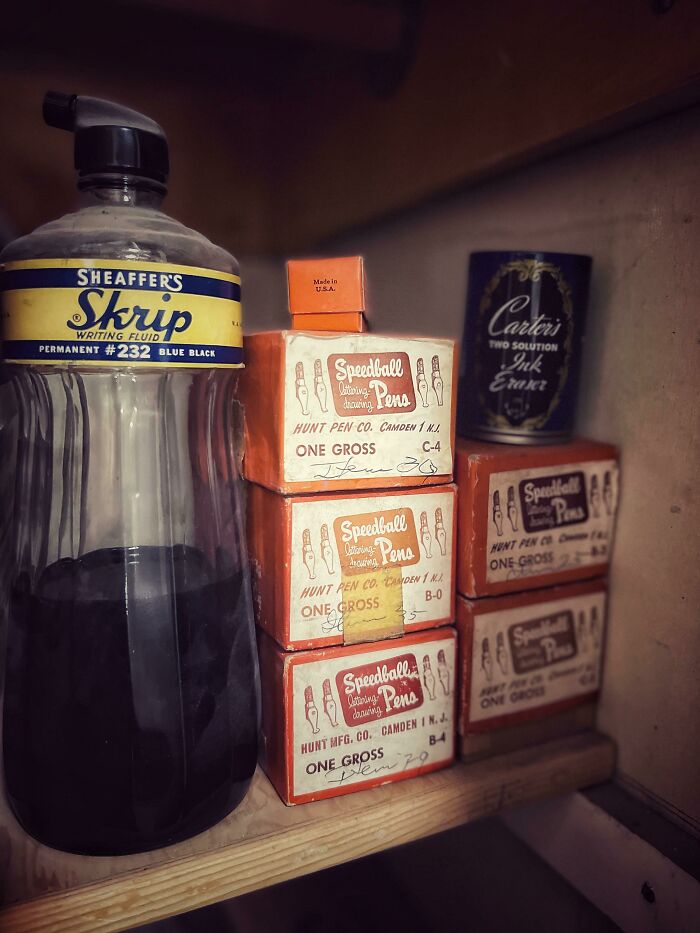 Botella y cajas de tinta y plumas antiguas mostrando la vida cotidiana en la década de 1950.