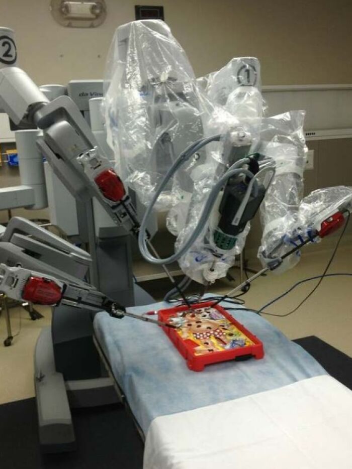 Robot quirúrgico en sala médica realizando procedimiento con instrumentos delicados, mostrando avances en fotos médicas aterradoras.